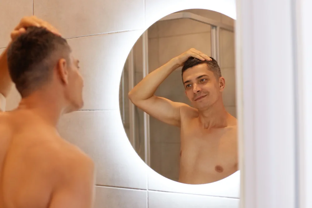 Man looking into a mirror at home on a schizophrenia mental health information page